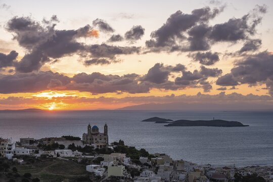 View from Ano Syros to the houses of Ermoupoli with the Anastasi Church or Church of the Resurrection, town view with islands and sea, dramatic cloudy sky at sunrise, Ano Syros, Syros, Cyclades, Greece