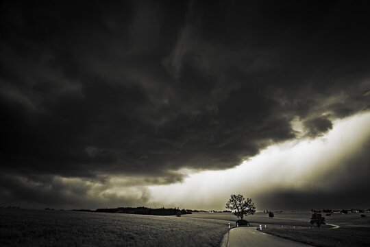 Road and meadows with thunderstorm sky in the background, Eggental, Ostallg&auml;u, Swabia, Bavaria, Germany