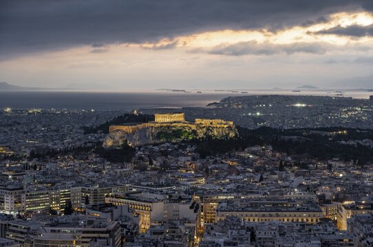 View over the sea of houses of Athens, illuminated Parthenon temple on the Acropolis, from Mount Lycabettus, Athens, Greece