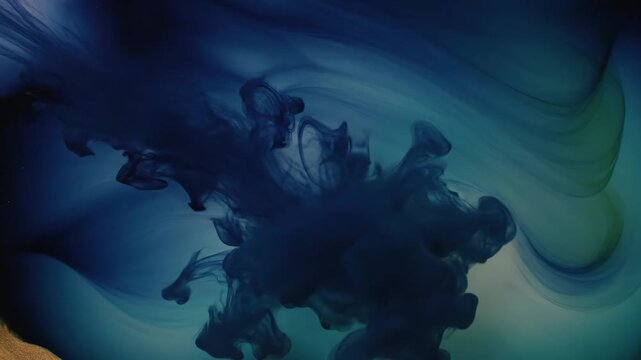 Dark blue ink cloud spreading and dissolving in turquoise water creating a beautiful abstract pattern. Ethereal fluid art with a swirling smoke effect for a creative background