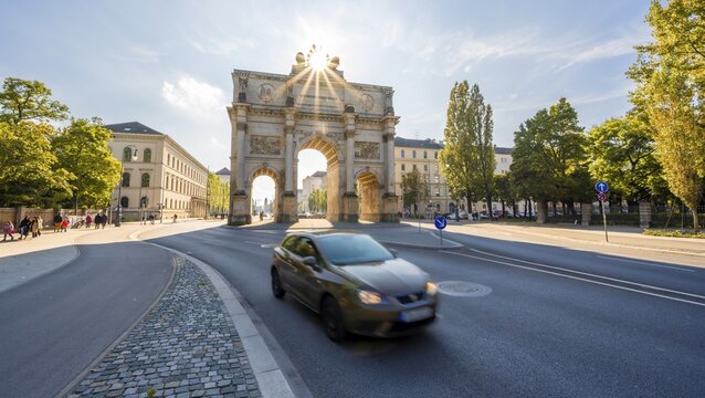 Sun Star, Siegestor, Car drives along Leopoldstrasse, Neoclassical architecture, Bavaria, Munich, Bavaria, Germany