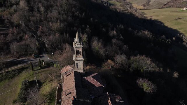 Castello di Monteventano fortified complex with church tower dominating countryside near Piozzano, Province of Piacenza, Emilia-Romagna, Italy, rural hilltop landscape revealed in aerial view.