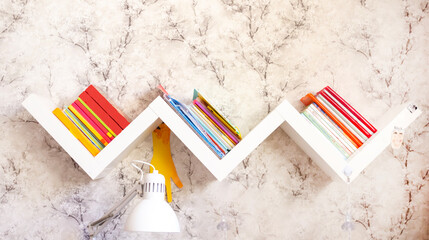 Zigzag bookshelf with books on a light wall