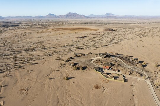The Doro Nawas Camp and arid desert plains at the edge of the dry river bed of the Aba-Huab river, aerial view, drone shot, Damaraland, Kunene Region, Namibia