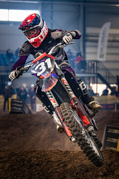 Latvia, Riga August 27, 2025,  regular training Motorcyclist performing a jump on a dirt track in an indoor arena