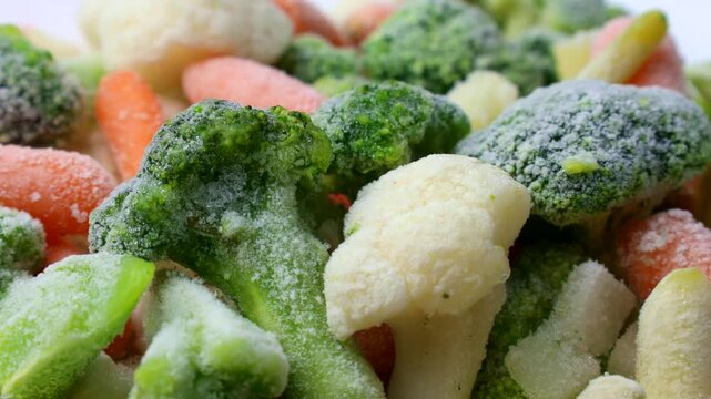 Assorted frozen vegetables (broccoli, carrots, cauliflower, beans) circle rotation close up