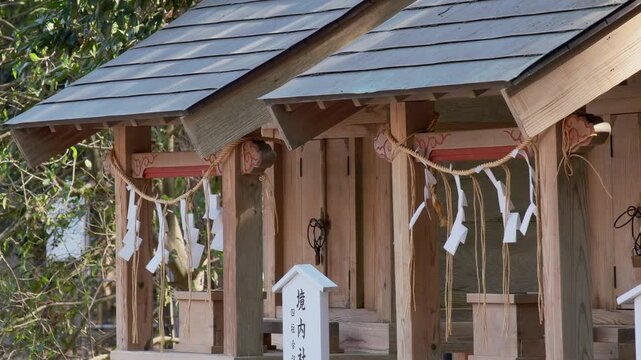 神社の境内にある摂末社としめ縄の揺れる風景