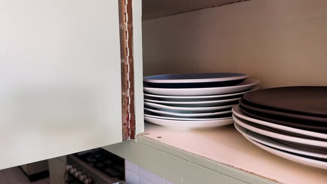 the plates are stacked in the kitchen cabinet