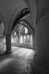 Obraz premium Historic cloister corridor with vaulted arches and frescoes in black and white