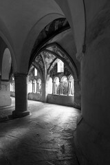 Fototapeta premium Historic cloister corridor with vaulted arches and frescoes in black and white