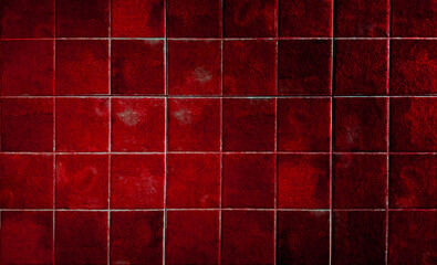 Industrial dark red textured ceramic square tiles wall background. Weathered rustic crimson grid tile pattern for interior design, bathroom, or kitchen backdrop. Gritty vintage stone surface.