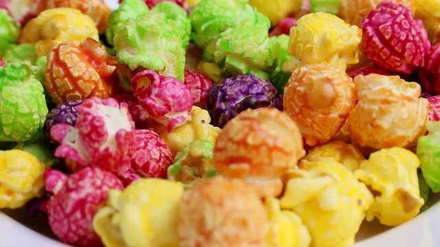 Bright colorful fruit caramel popcorn falling down close up