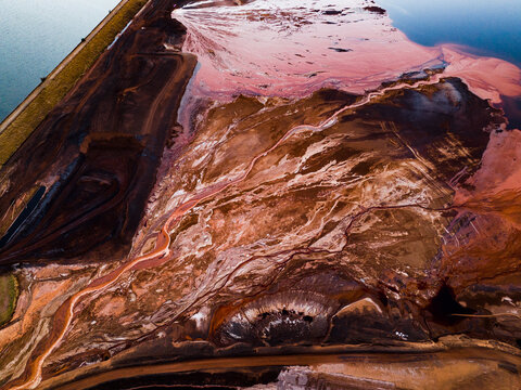 Aerial view of parched earth meeting the serene blue of the ocean, a stark contrast of nature's elements, Aluminium Refinery, Western Australia, Australia.