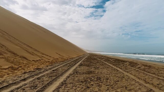 Sandwich Harbour in Namibia at the coast of the Atlantic Ocean. Sandy beach. Sandwich Harbor roundtrip daytime car tour