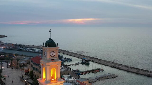 Aerial view of St. Peters Church bell tower in Old Jaffa overlooking the Mediterranean sea and Tel Aviv city skyline at sunset