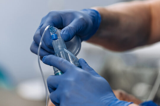 Anesthesiologist inserting endotracheal tube to induce general anesthesia in sterile operating room. Clinical procedure concept.
