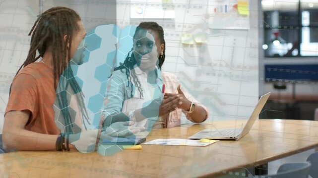 Woman holding red pen pointing at laptop explaining project, man using touchpad, blue hex overlay