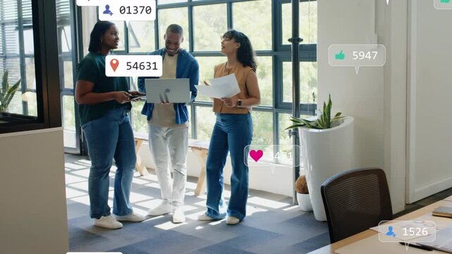 Man tapping laptop, causing notifications floating around team while reviewing marketing papers
