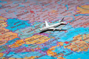 Naklejka premium Airplane model over the map of Ukraine representing air travel and airspace status.
