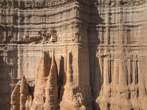 Aerial view of the dramatic, layered sandstone formations, sculpted by time and weather, casting shadows that accentuate the rugged beauty of the landscape, Teruel, Aragon, Spain.