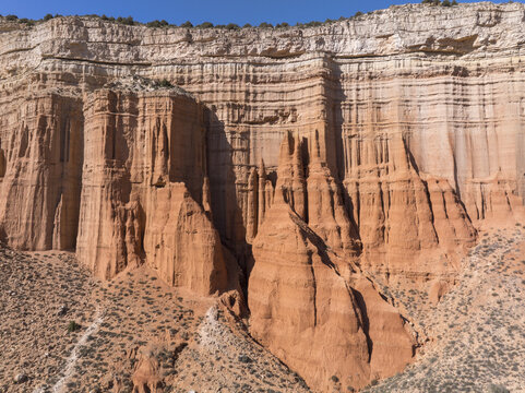 Aerial view of the rugged, sun-baked slopes of Los Organos, where terracotta hues meet pale ochre in a symphony of geological artistry, Teruel, Aragon, Spain.