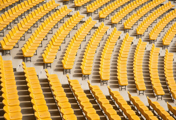 Rows of empty yellow chairs in an auditorium