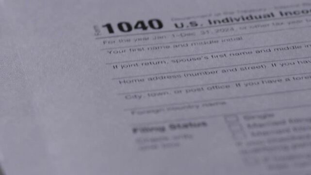 Close up shot of U.S. Individual Income Tax Return form 1040. Flipping through paper pages of tax documents during the financial filing season