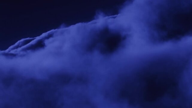Dramatic blue storm clouds rolling overhead in night sky
