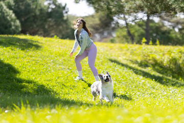 Woman playing with dog in sunny park