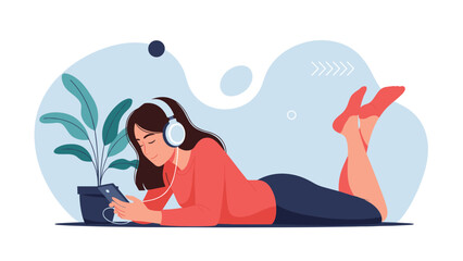 Obraz premium Young woman relaxing on her stomach, listening to music with headphones and interacting with her smartphone, enjoying peaceful leisure time at home.