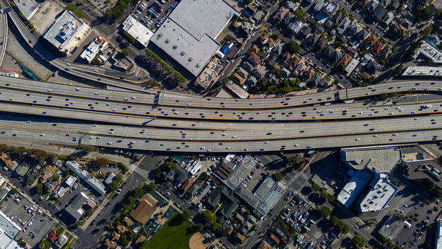 Aerial view of a sprawling freeway teeming with cars cutting through a dense urban landscape, Los Angeles, California, United States.
