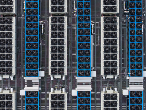 Aerial view of tightly packed industrial cooling units atop the Mainova WebHouse, their dark fans contrasting with the blue frames, Frankfurt am Main, Hessen, Germany.