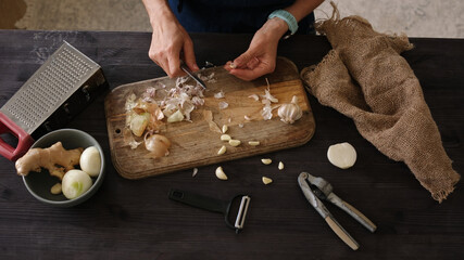 Woman Cleaning Garlic In A Close-Up Top View