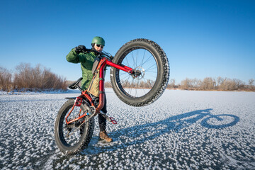 senior male cyclist with his fat mountain bike on a frozen lake in northern Colorado