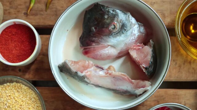 Traditional Bengali ingredients for Fish Head Lentils (Macher Matha diye Moong Dal) on a rustic background.