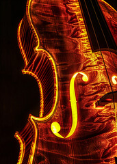 a close up shot of a brightly lit violin with a black background and a warm glow on the instrument's