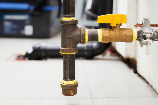Shut-off valve for natural gas heating in home. Brass ball valve with yellow handle.  Quarter-turn mechanism. Gas system safety device to repair, maintain or turn off. Selective focus.