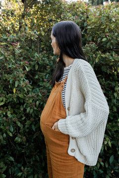 Pregnant Woman outside holding belly