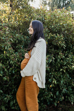 Pregnant Woman outside holding belly