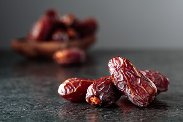 Obraz premium Dried dates fruit on a black table.