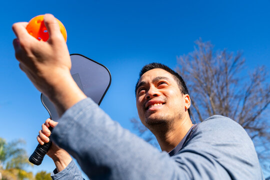 Man playing pickleball outside 