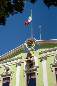 Bright Green Building With Mexican Flag Under Clear Blue Sky