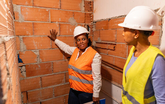 two architects checking a wall