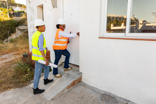 A pair of female inspectors walk towards a construction site