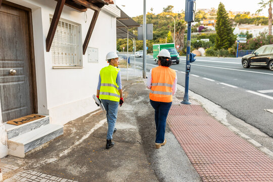 A pair of female inspectors walk towards a construction site