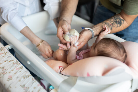 A couple washing their newborn baby
