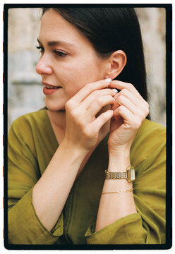 Woman putting on earring 