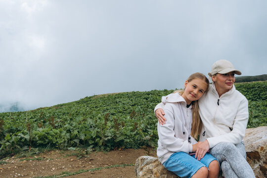 Family bonding during mountain trip with soft clouds in sky
