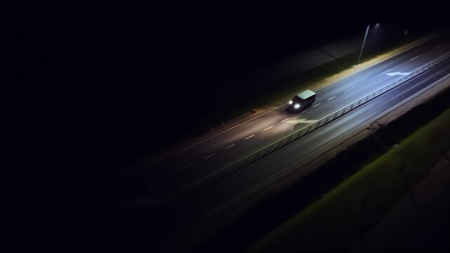 Passenger van driving in darkness, traveling in night. Minibus moving on road at night, headlights lighting path. Van cruising along nighttime street, beams illuminating direction. Transport vehicle