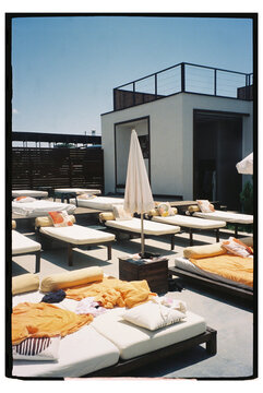 Lounging area at rooftop pool with sunbeds on a sunny day